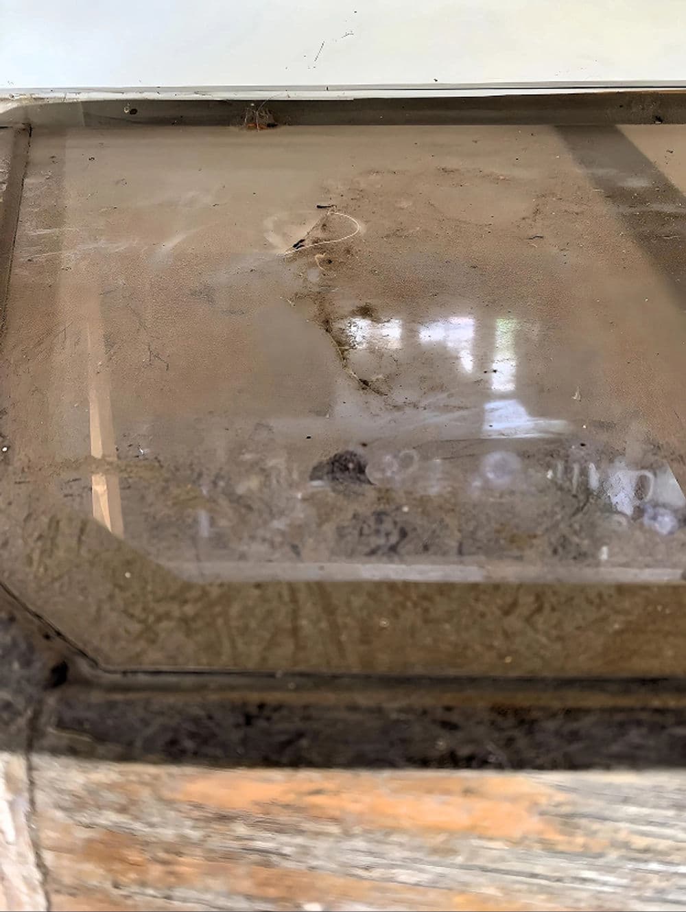 Dirty glass surface with dust and grime, revealing wear over time.