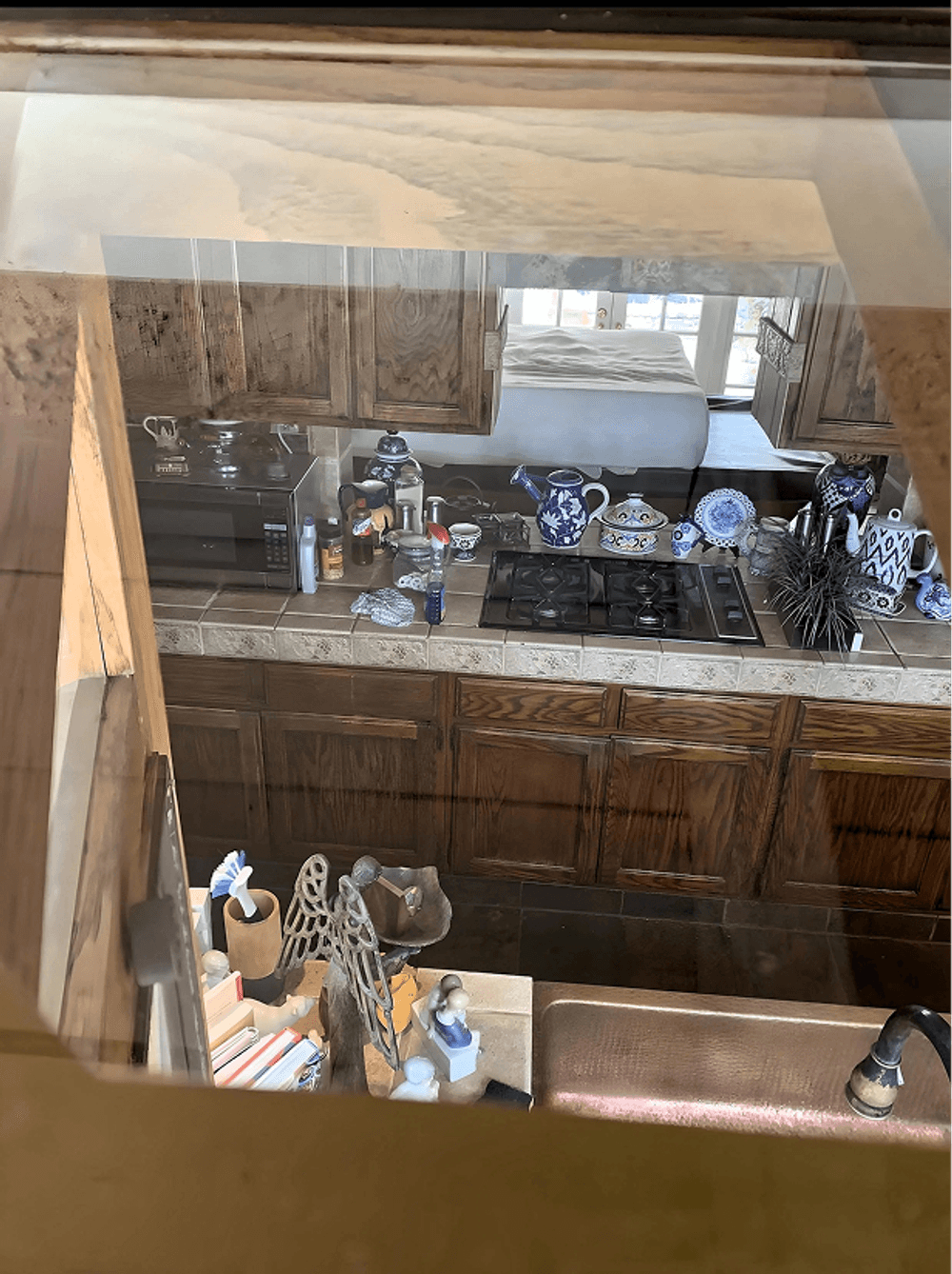Modern kitchen with wooden cabinetry, blue and white ceramics, and stainless steel appliances.
